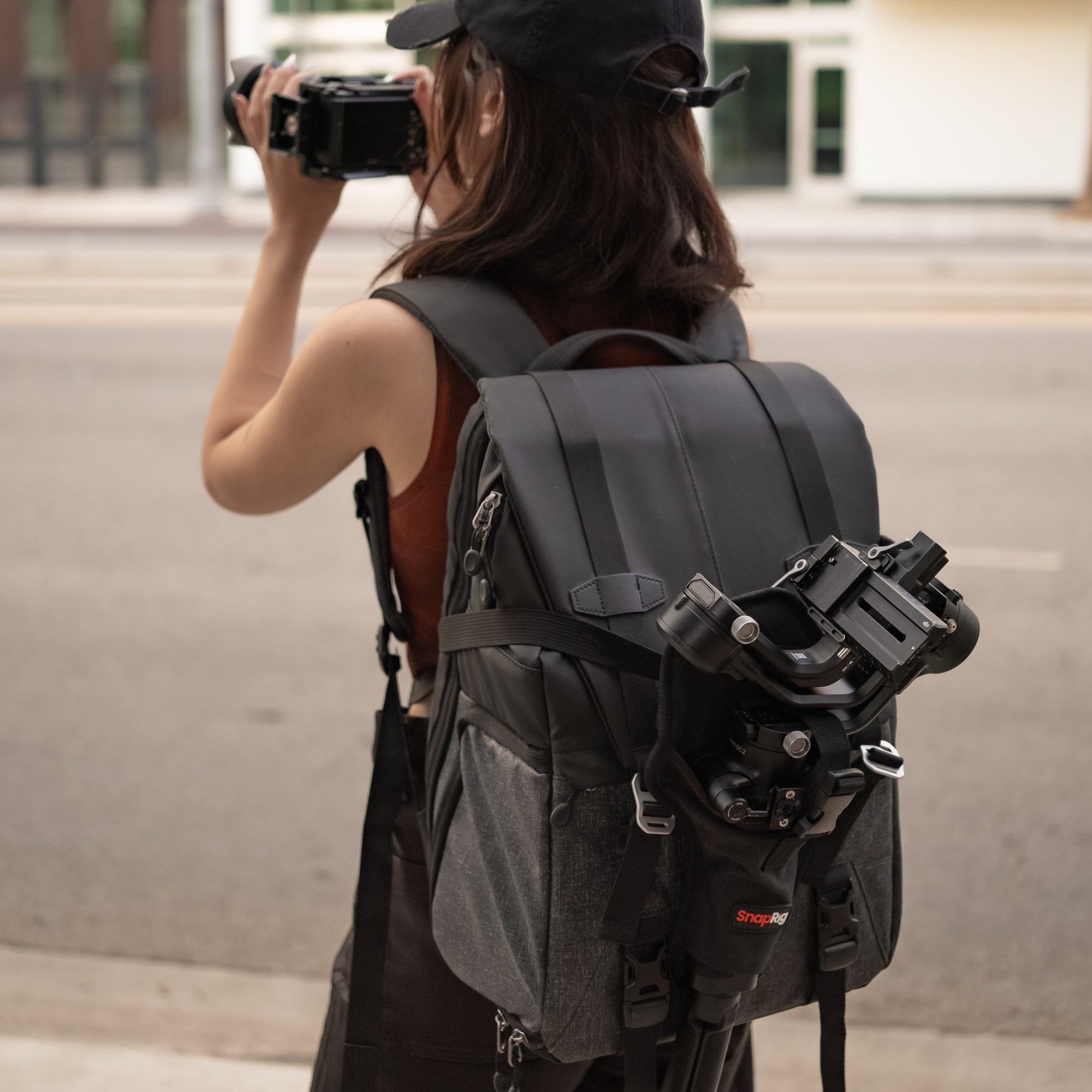Videographers attach Gimbal Holster on a backpack